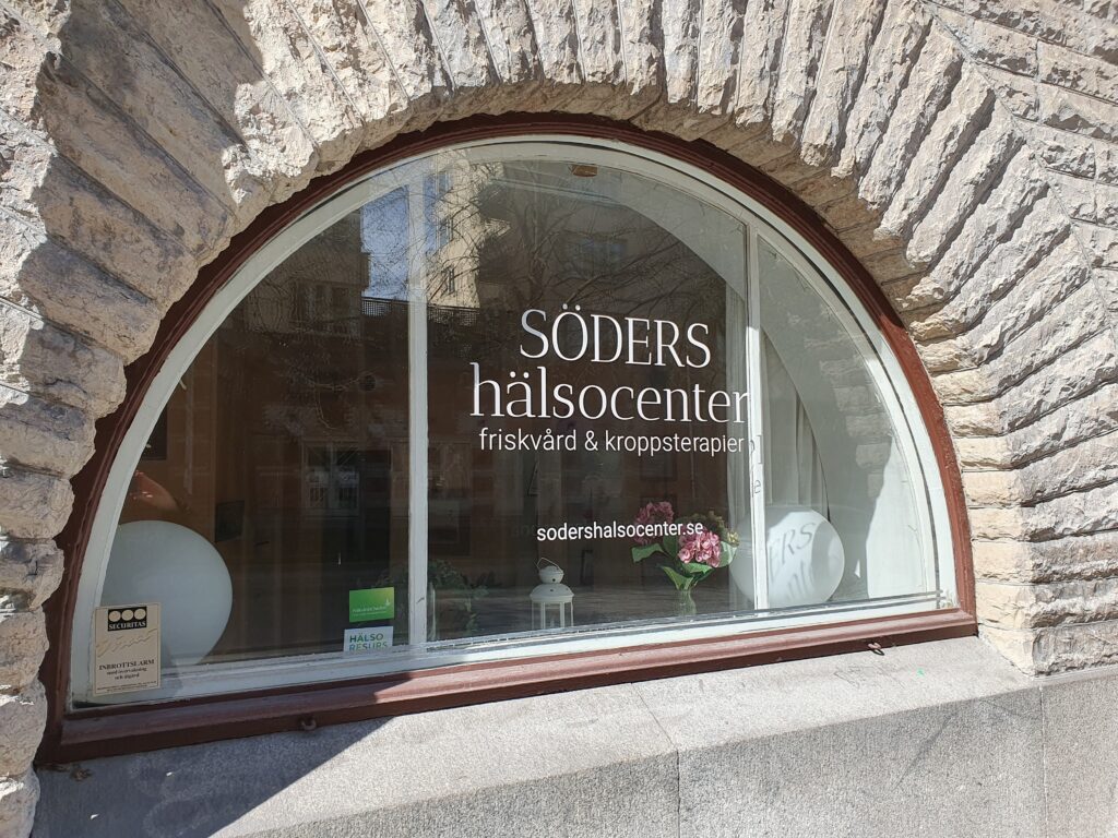 Ett halvcirkelformat fönster med texten Söders hälsocenter